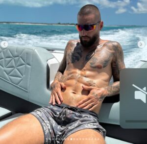 Maluma sentado sin camisa desnudo posando en un yate en instagram